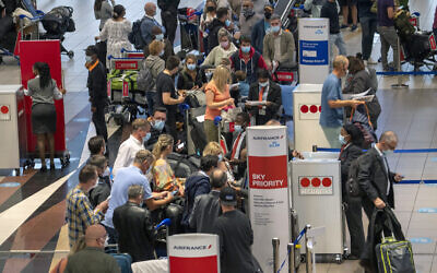 People line up to get on the Air France flight to Paris at OR Tambo International Airport in Johannesburg, South Africa, Friday Nov. 26, 2021. (AP Photo/Jerome Delay)
