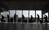 Travelers walk with their luggage in  Ben Gurion Airport near Tel Aviv, November 28, 2021. (AP/Ariel Schalit)