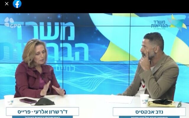 Screen capture from video of Health Ministry director of public health Dr. Sharon Alroy-Preis, left, and comedian Nadav Abuksis during a ministry broadcast on COVID-19 vaccinations, November 9, 2021. (Facebook) Screen capture from video of Health Ministry director of public health Dr. Sharon Alroy-Preis, left, and comedian Nadav Abuksis during a ministry broadcast on COVID-19 vaccinations, November 9, 2021. (Facebook)
