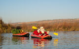 Issa Anis Kassissieh, the official Ambassador of the Holy Land Santa, kayaks in the Jordan River in the Golan Heights as part of his Christmas 2021 greeting. (Courtesy: Omri Masika and Roi Peretz)