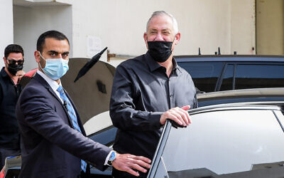 Benny Gantz is seen getting into a car next to a personal security guard, in Tel Aviv, on March 15, 2021. (Avshalom Sassoni/Flash90)