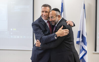 Newly appointed Minister of Religious Services Matan Kahana (Yamina) with outgoing Minister Yaakov Avitan (Shas), at a ceremony marking the transfer of authority at the ministry on June 14, 2021. (Yonatan Sindel/Flash90)