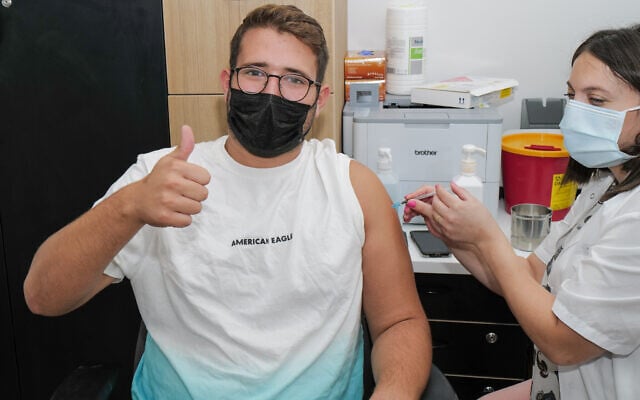 An Israeli receives a third dose of the COVID-19 vaccine at a Maccabi Health Care center in Katsrin, Golan Heights, October 7, 2021. (Michael Giladi/Flash90)