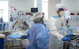 Hospital workers wearing safety work in the coronavirus ward at Shaare Zedek Medical Center in Jerusalem on October 14, 2021. (Olivier Fitoussi/Flash90)