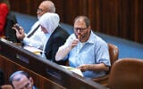 Joint List MK Ofer Cassif eats a lollipop in the Knesset in Jerusalem on November 3, 2021. (Olivier Fitoussi/Flash90)