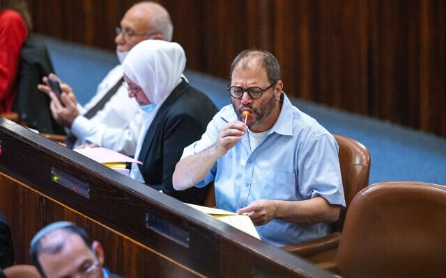 Joint List MK Ofer Cassif eats a lollipop in the Knesset in Jerusalem on November 3, 2021. (Olivier Fitoussi/Flash90) Joint List MK Ofer Cassif eats a lollipop in the Knesset in Jerusalem on November 3, 2021. (Olivier Fitoussi/Flash90)