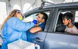 Healthcare workers take samples at a drive through complex for coronavirus testing, in Modi'in, on November 10, 2021 (Yossi Aloni/Flash90)