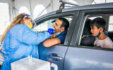 Health care staff test for COVID-19 at a drive through complex in Modi'in, on November 10, 2021. (Yossi Aloni/Flash90)