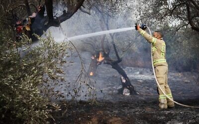 Firefighter works to extinguish a fire in Ma'alot-Tarshiha, northern Israel, on November 14, 2021 (David Cohen/Flash90)