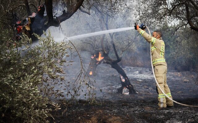 Firefighter works to extinguish a fire in Ma'alot-Tarshiha, northern Israel, on November 14, 2021 (David Cohen/Flash90)