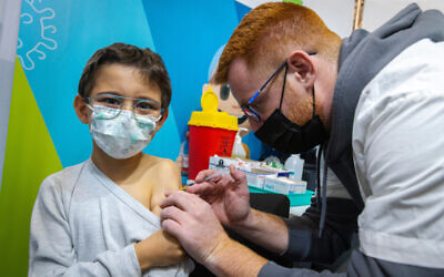 Illustrative: A child receives their first dose of COVID-19 vaccine at a Clalit vaccine center in Jerusalem, on November 23, 2021. (Olivier Fitoussi/Flash90)