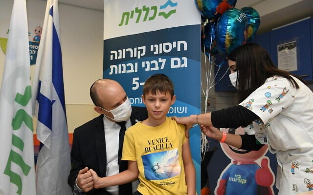 Prime Minister Naftali Bennett takes his 9-year-old son to get vaccinated against COVID on November 23, 2021 (Amos Ben Gershom/GPO) Prime Minister Naftali Bennett takes his 9-year-old son to get vaccinated against COVID on November 23, 2021 (Amos Ben Gershom/GPO)