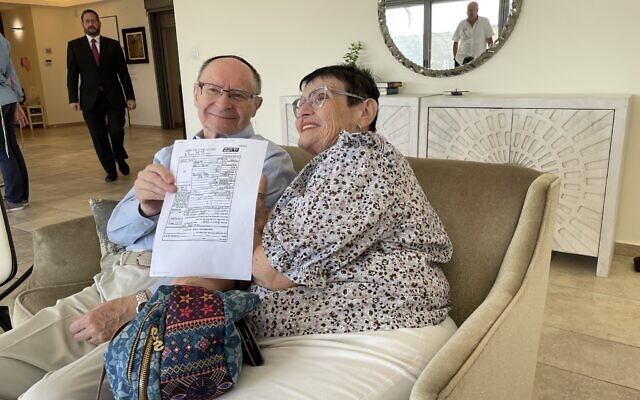 Holocaust survivor Bernard Krutz and his first cousin Esti Kisseloff meet for the first time on November 4, 2021, with the 1956 Yad Vashem testimony that helped prove their familial relationship. (Jessica Steinberg/Times of Israel)