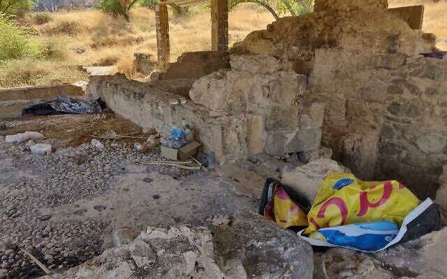 An ancient Roman and Byzantine bathhouse unearthed in Tiberias lies neglected, under piles of garbage and housing a homeless person, October 19, 2021. (Michael Bachner/Times of Israel)