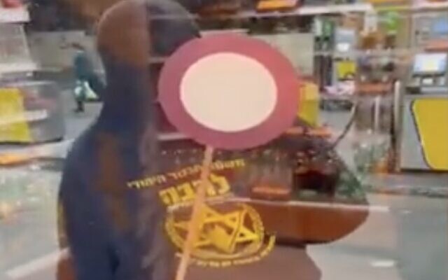 Screen capture from video of a member of the Jewish far-right Lehava group attacking a gas station store as Arab workers hide inside, November 6, 2021. (Channel 13 News) Screen capture from video of a member of the Jewish far-right Lehava group attacking a gas station store as Arab workers hide inside, November 6, 2021. (Channel 13 News)