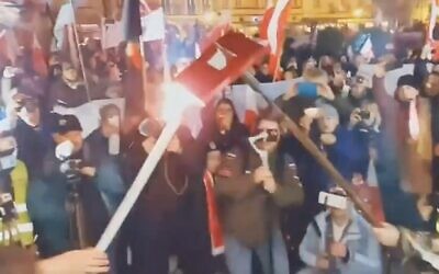 Nationalist rally-goers burn a book representing a historic pact protecting the rights of Poland’s Jews in Kalisz, Poland, Nov. 11, 2021. (Screenshot from Karolina Pawliczak/Twitter)