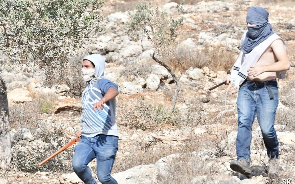 Israelis descend a hillside during an alleged assault on Palestinians and left-wing Israeli activists near the Bat Ayin outpost in the West Bank, on November 12, 2021 (Credit: Shai Kendler) Israelis descend a hillside during an alleged assault on Palestinians and left-wing Israeli activists near the Bat Ayin outpost in the West Bank, on November 12, 2021 (Credit: Shai Kendler)