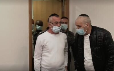 Screen capture from video of Yitzhak Abergil, center, entering a courtroom at the Tel Aviv District Court, November 16, 2021. (Ynet)