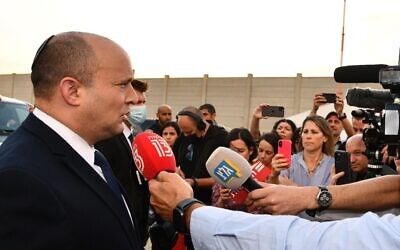 Prime Minister Naftali Bennett talks to reporters before boarding a plane to Scotland for the COP 26 United Nations climate talks, October 31, 2021. ( Haim Zach GPO)