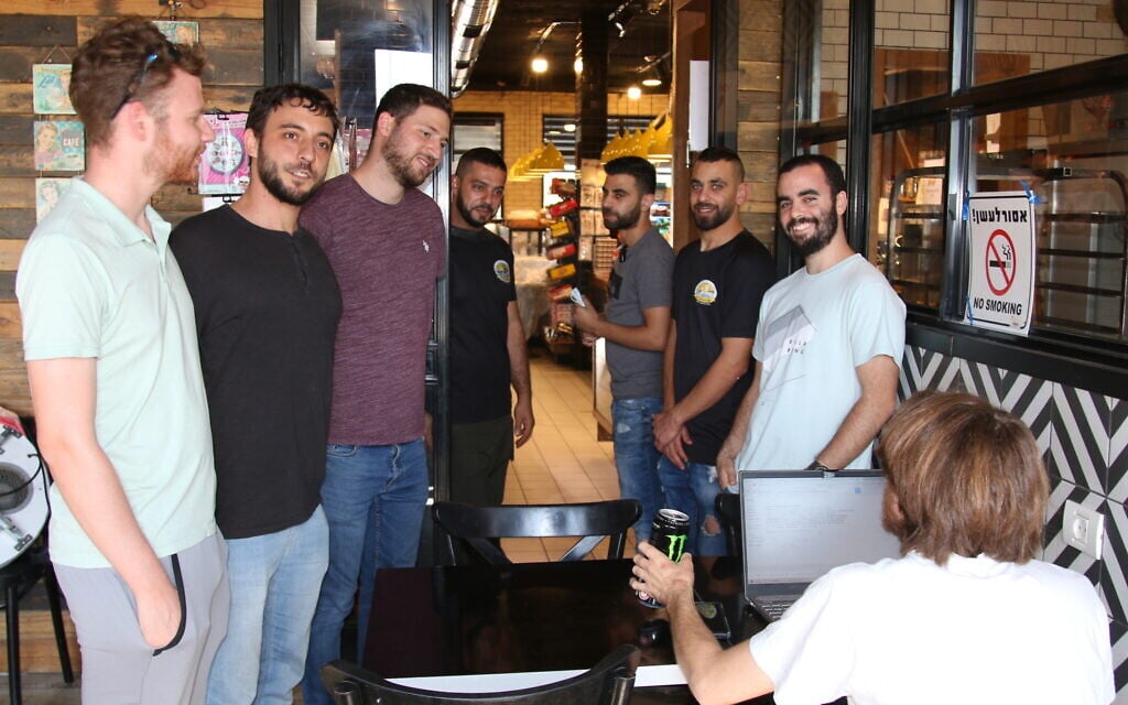 Blend.ar participants chat with fellow workers before a shift volunteering in a restaurant in Abu Ghosh, October 2021. (Shmuel Bar-Am)