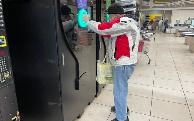 A shopper tries out the bottle deposit automat at a Talpiot, south Jerusalem, branch of the Yochananoff supermarket chain, November 23, 2021. (Sue Surkes/Times of Israel) A shopper tries out the bottle deposit automat at a Talpiot, south Jerusalem, branch of the Yochananoff supermarket chain, November 23, 2021. (Sue Surkes/Times of Israel)