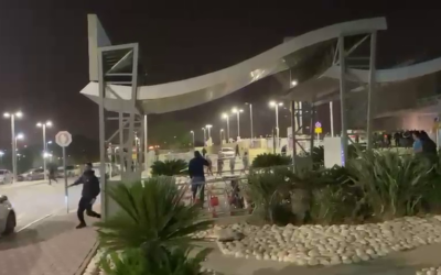 A police officer runs as shots are fired during a brawl outside Soroka Medical Center in Beersheba, November 14, 2021. (Video screenshot)