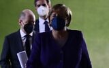 German Chancellor Angela Merkel (R) arrives with her designated successor Olaf Scholz (L) for a press conference following a meeting with the heads of Germany's federal states, at the Chancellery in Berlin, on December 2, 2021. (John MacDougall/Pool/AFP)