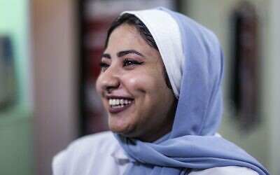 Shoruk Shaheen, a Palestinian woman who has undergone dimple creation surgery, smiles at a clinic in Gaza City on November 30, 2021 (MAHMUD HAMS / AFP)