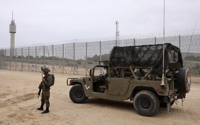 An Israeli soldier pictured by the newly completed barrier above and below the border with the Gaza Strip, near Moshav Netiv HaAsara in southern Israel on December 7, 2021. (MENAHEM KAHANA / AFP) An Israeli soldier pictured by the newly completed barrier above and below the border with the Gaza Strip, near Moshav Netiv HaAsara in southern Israel on December 7, 2021. (MENAHEM KAHANA / AFP)