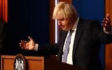 Britain's Prime Minister Boris Johnson gestures during a press conference for the latest COVID-19 update in the Downing Street briefing room in central London on December 8, 2021 (Adrian DENNIS / POOL / AFP)