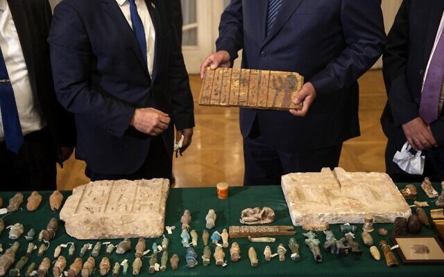 Foreign Minister Yair Lapid (L) presents Egypt's Foreign Minister Sameh Shoukry (R) with stolen Egyptian artifacts that were smuggled to Israel and returned back to Egypt, during their meeting at Tahrir Palace in Cairo on December 9, 2021. (Mohamed HOSSAM / AFP) Foreign Minister Yair Lapid (L) presents Egypt's Foreign Minister Sameh Shoukry (R) with stolen Egyptian artifacts that were smuggled to Israel and returned back to Egypt, during their meeting at Tahrir Palace in Cairo on December 9, 2021. (Mohamed HOSSAM / AFP)