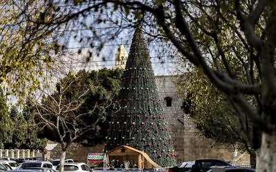 A giant Christmas tree is seen at outside the Church of the Nativity, in the West Bank city of Bethlehem, on December 15, 2021. (Abbas Momani/AFP)