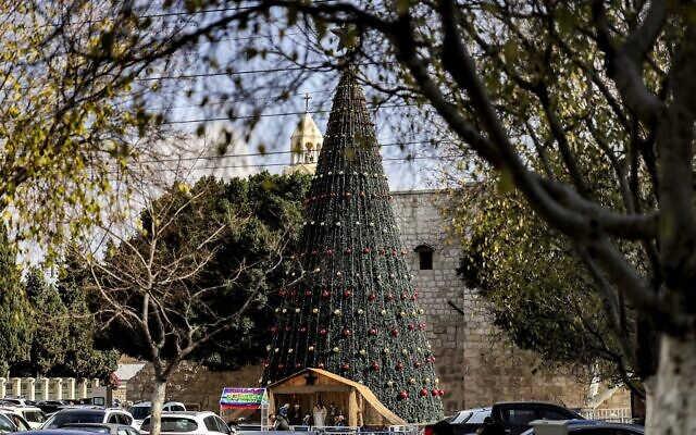 A giant Christmas tree is seen at outside the Church of the Nativity, in the West Bank city of Bethlehem, on December 15, 2021. (Abbas Momani/AFP) A giant Christmas tree is seen at outside the Church of the Nativity, in the West Bank city of Bethlehem, on December 15, 2021. (Abbas Momani/AFP)