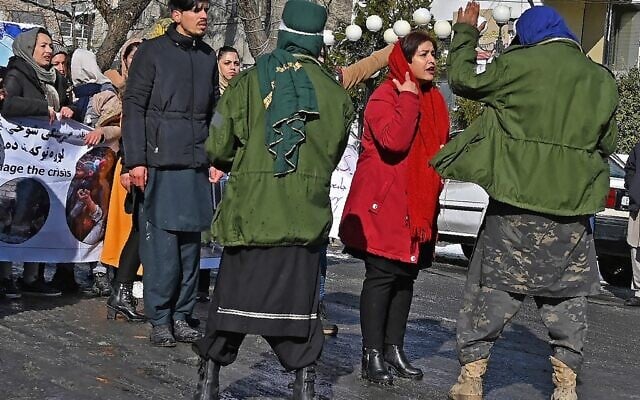 An Afghan woman protester (2R) speaks with Taliban fighters during a demonstration at Shahr-e Naw in Kabul on December 16, 2021, demanding the right to education, jobs and political representation from the Taliban government. (Wakil KOHSAR / AFP)