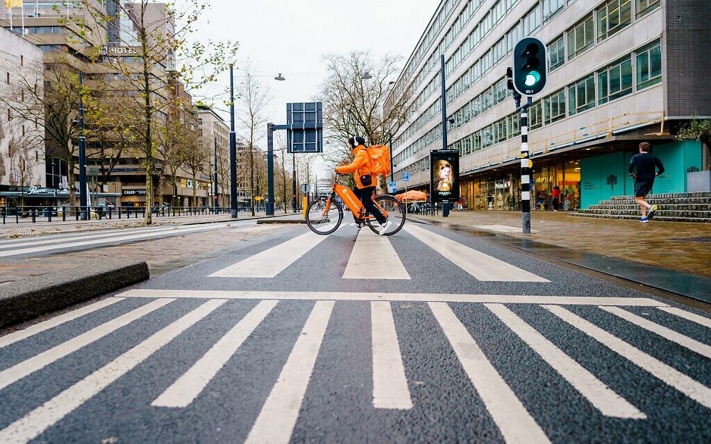 A cyclist working for a delivery company rides on an empty road downtown Rotterdam on December 19, 2021, on the first day of The Netherlands' lockdown over the Christmas period to try to stop a surge of the Omicron coronavirus variant. (Marco de Swart/ANP/AFP) A cyclist working for a delivery company rides on an empty road downtown Rotterdam on December 19, 2021, on the first day of The Netherlands' lockdown over the Christmas period to try to stop a surge of the Omicron coronavirus variant. (Marco de Swart/ANP/AFP)