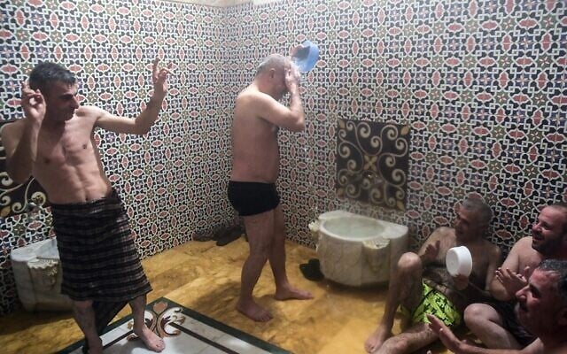 Men bathe at Hammam al-Qawas, a traditional Turkish bathhouse, in Syria's northern city of Aleppo on December 16, 2021. (Photo by AFP)