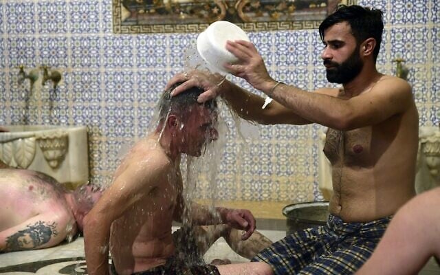 Men bathe at Hammam al-Qawas, a traditional Turkish bathhouse, in Syria's northern city of Aleppo on December 16, 2021. (Photo by AFP)
