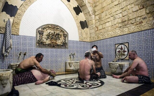 Men bathe at Hammam al-Qawas, a traditional Turkish bathhouse, in Syria's northern city of Aleppo on December 16, 2021. (Photo by AFP)
