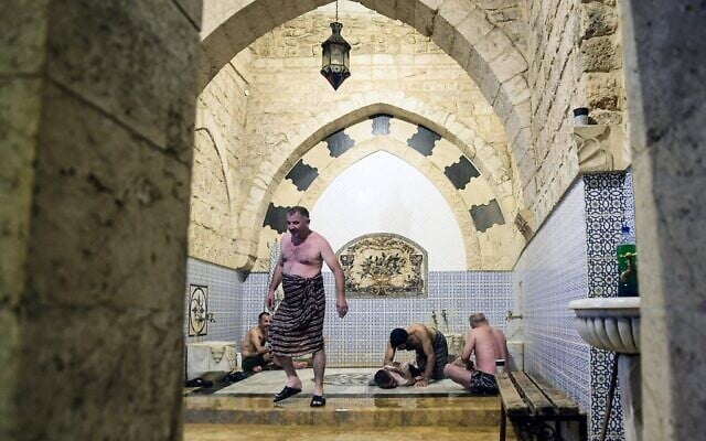 Men bathe at Hammam al-Qawas, a traditional Turkish bathhouse, in Syria's northern city of Aleppo on December 16, 2021. (Photo by AFP)