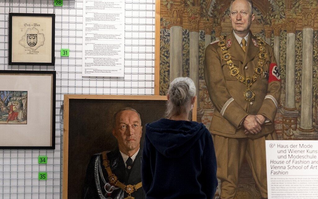 A visitor explores art works at an exhibition titled 'Vienna Falls in Line. The Politics of Art under National Socialism' showing Nazi artifacts at the city's Vienna Museum in Vienna, Austria, on November 9, 2021. (Joe Klamar/AFP)