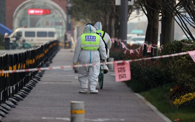 Security guards walk in an area that is under restrictions following a recent coronavirus outbreak in Xi'an in China's northern Shaanxi province on December 22, 2021. (AFP) Security guards walk in an area that is under restrictions following a recent coronavirus outbreak in Xi'an in China's northern Shaanxi province on December 22, 2021. (AFP)