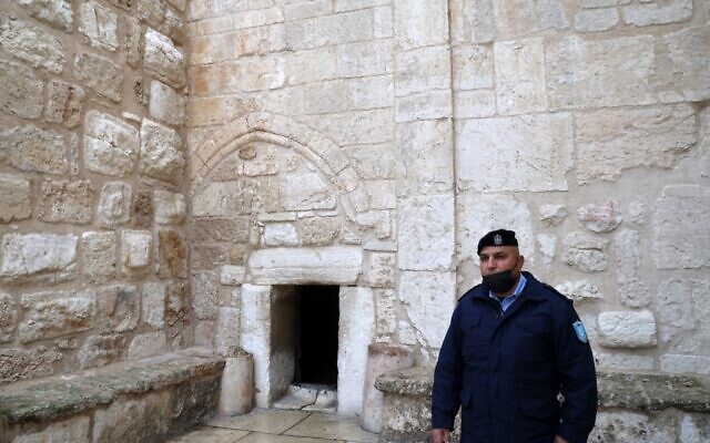 A member of the Palestinian security forces stands guard at the entrance of the Church of the Nativity, Bethlehem, December 24, 2021. (Jaafar Ashtiyeh / AFP) A member of the Palestinian security forces stands guard at the entrance of the Church of the Nativity, Bethlehem, December 24, 2021. (Jaafar Ashtiyeh / AFP)