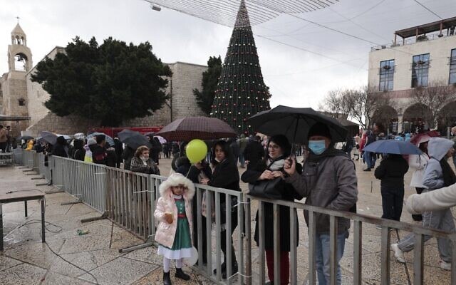 People gather outside the Church of the Nativity, revered as the site of Jesus Christ's birth, during Christmas celebrations in Bethlehem on December 24, 2021. ( ABBAS MOMANI / AFP) People gather outside the Church of the Nativity, revered as the site of Jesus Christ's birth, during Christmas celebrations in Bethlehem on December 24, 2021. ( ABBAS MOMANI / AFP)