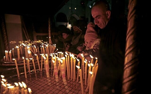 People visit the Church of the Nativity, revered as the site of Jesus Christ's birth, during Christmas celebrations in the biblical city of Bethlehem on December 24, 2021. (Abbas Momani/AFP) People visit the Church of the Nativity, revered as the site of Jesus Christ's birth, during Christmas celebrations in the biblical city of Bethlehem on December 24, 2021. (Abbas Momani/AFP)