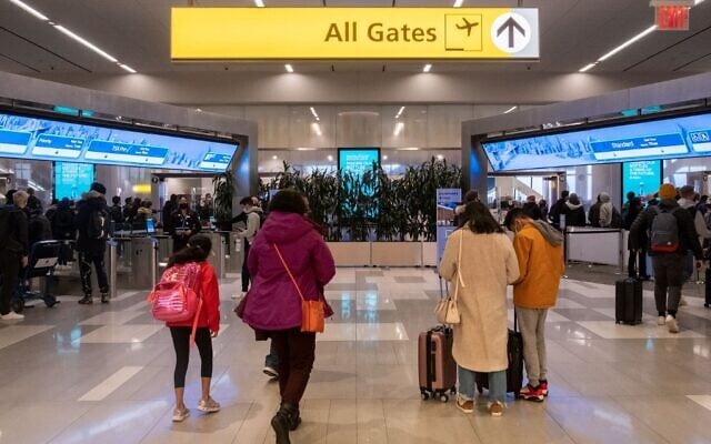 Travelers walk to a security checkpoint at LaGuardia Airport in New York, on December 24, 2021. (Yuki IWAMURA / AFP) Travelers walk to a security checkpoint at LaGuardia Airport in New York, on December 24, 2021. (Yuki IWAMURA / AFP)