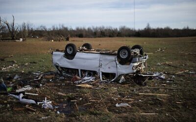 An overturned passenger van rests in an empty field in a rural neighborhood that was ravaged by a tornado the night before in Mayfield, Kentucky, on December 11, 2021. (Photo by Brett Carlsen / GETTY IMAGES NORTH AMERICA / Getty Images via AFP)