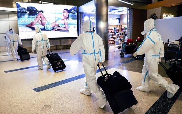 Air China flight crew members wear protective suits as they arrive in the international terminal at Los Angeles International Airport (LAX) on December 3, 2021 in Los Angeles, California. A new rapid COVID-19 testing site for international arriving passengers opened today in the Tom Bradley International Terminal after Los Angeles County confirmed its first case of the Omicron variant December 2. (Mario Tama/Getty Images/AFP) Air China flight crew members wear protective suits as they arrive in the international terminal at Los Angeles International Airport (LAX) on December 3, 2021 in Los Angeles, California. A new rapid COVID-19 testing site for international arriving passengers opened today in the Tom Bradley International Terminal after Los Angeles County confirmed its first case of the Omicron variant December 2. (Mario Tama/Getty Images/AFP)