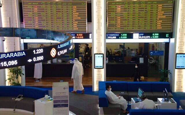 Illustrative: Emiratis wearing face masks due to the coronavirus pandemic work on the floor of the Dubai Financial Market in Dubai, United Arab Emirates, July 7, 2020. (Jon Gambrell/AP)