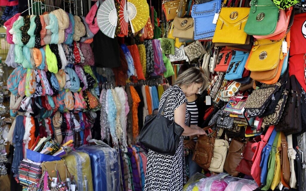 Illustrative: A woman looks through a display of purses on Canal Street in New York, June 4, 2013. (AP Photo/Seth Wenig)