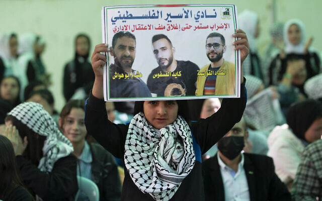 Protesters carry posters showing Kayed Fasfous, a Palestinian prisoner who has been on hunger strike for 120 days to protest being detained without charge by Israel, in the village of ad-Dhahiriya, near Hebron, Thursday, Nov. 11, 2021. (AP Photo/Majdi Mohammed) Protesters carry posters showing Kayed Fasfous, a Palestinian prisoner who has been on hunger strike for 120 days to protest being detained without charge by Israel, in the village of ad-Dhahiriya, near Hebron, Thursday, Nov. 11, 2021. (AP Photo/Majdi Mohammed)